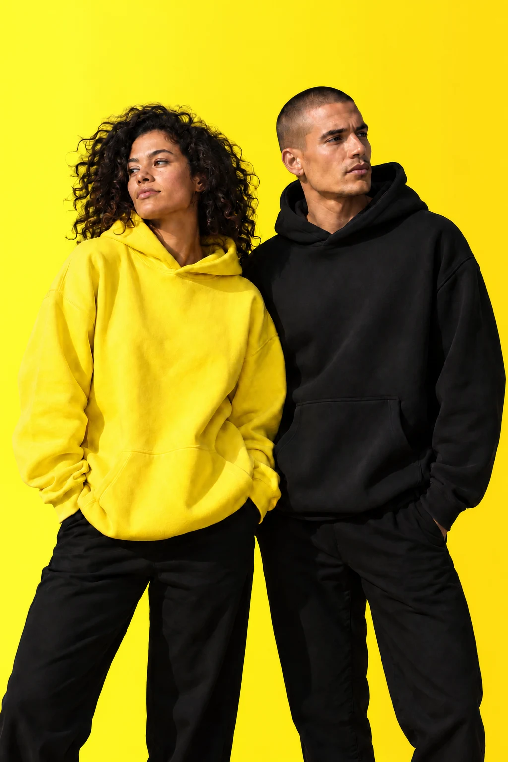 Two models wearing yellow and black hoodies